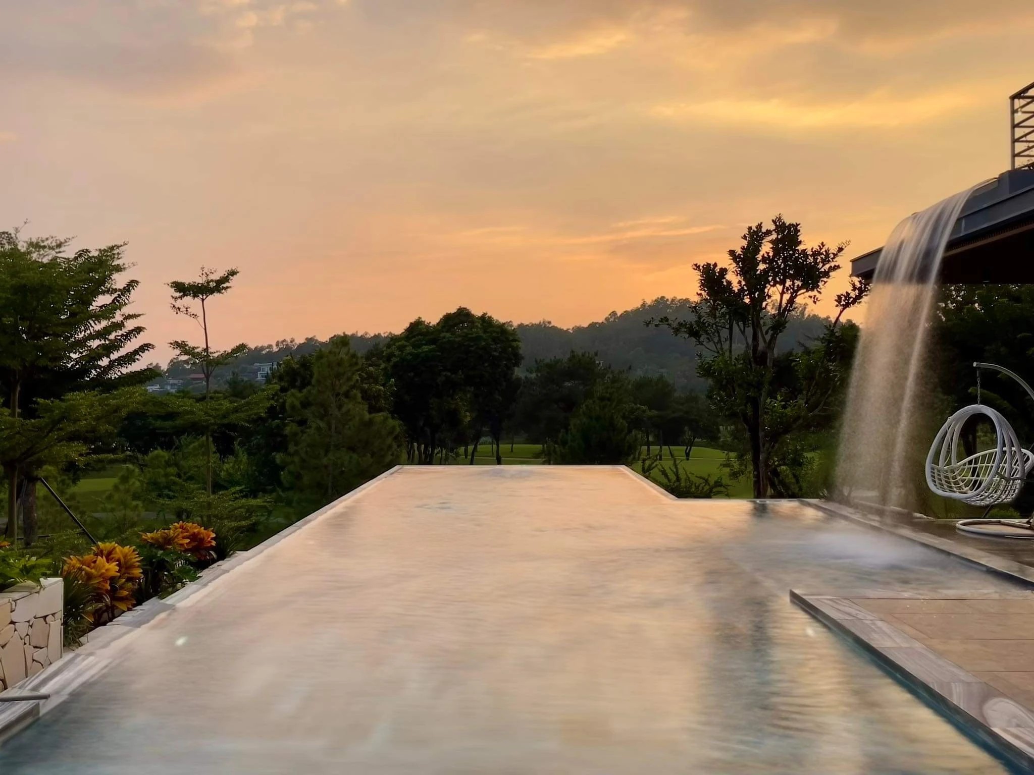 Chiều — bể bơi vô cực mặt nước phẳng hoàng hôn cam thiền viện Moon Villa